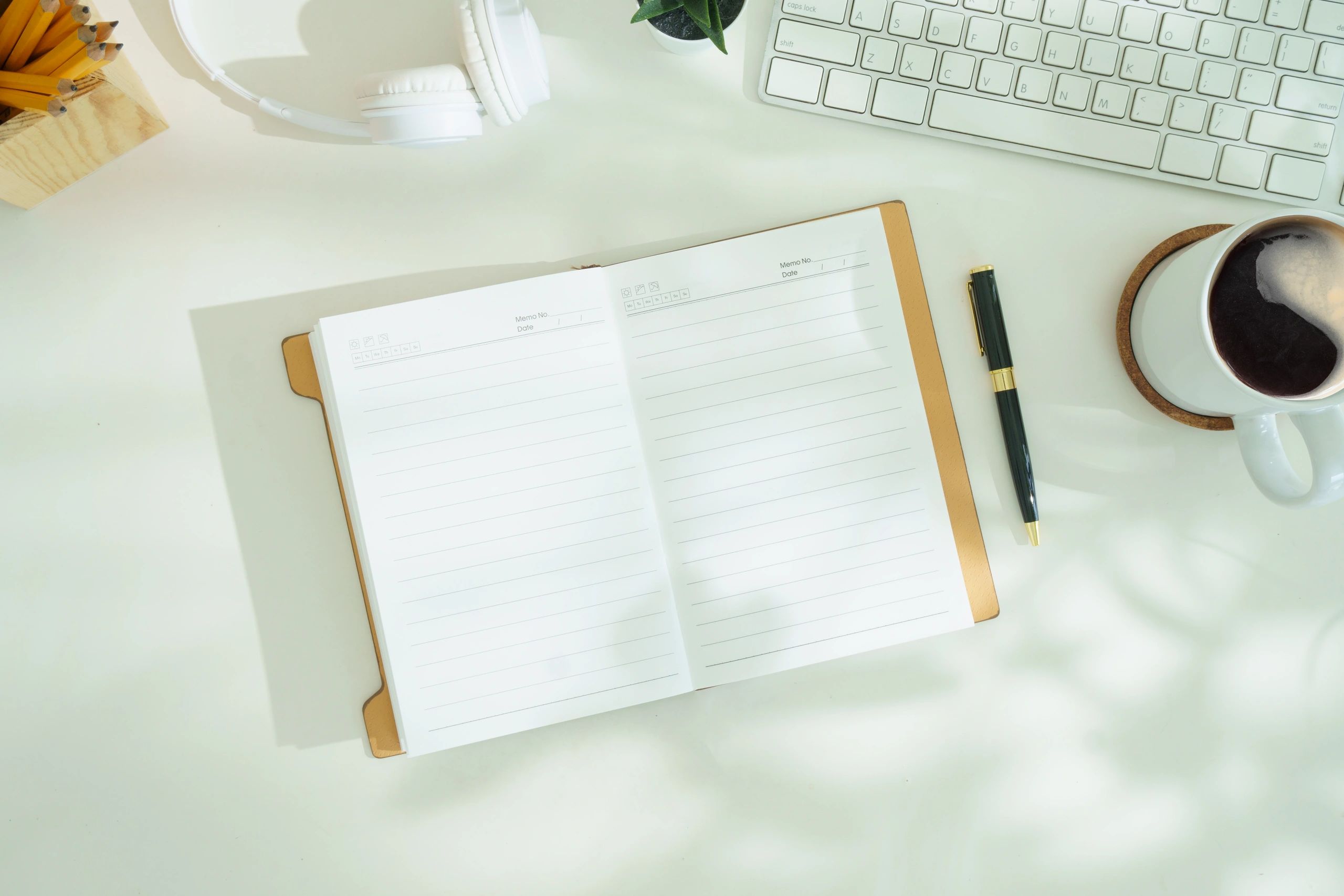 Notepad, phone, laptop, and coffee on an office desk